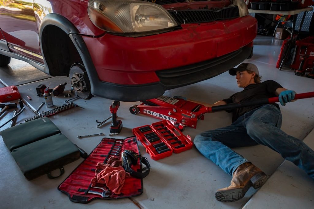 a-man-working-on-a-car-in-a-garage-n99utgfbvfq
